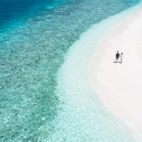 Couple walking the shoreline at Embudu